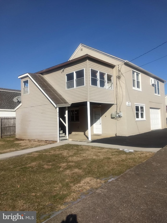 rear view of property with entry steps, a yard, and fence