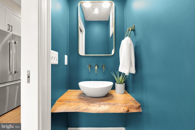 bathroom with wood finished floors and a sink