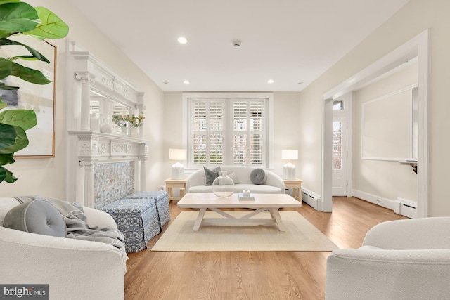 living room featuring light wood-type flooring, a baseboard heating unit, baseboard heating, and recessed lighting