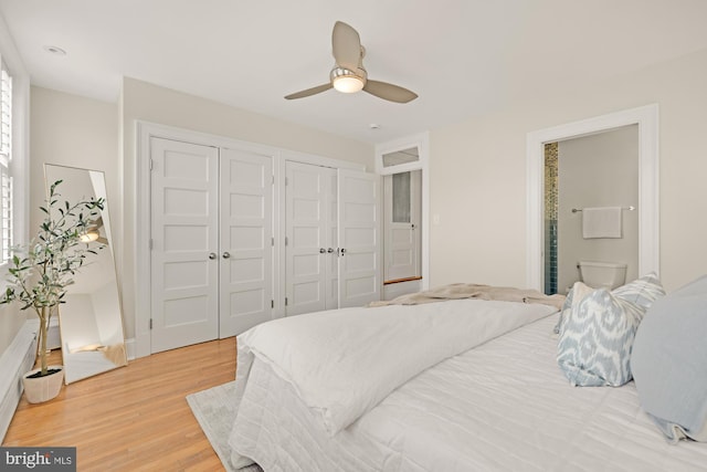 bedroom featuring multiple closets, a ceiling fan, and light wood finished floors