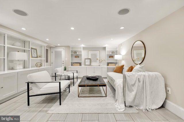 living area featuring recessed lighting, baseboards, and built in shelves