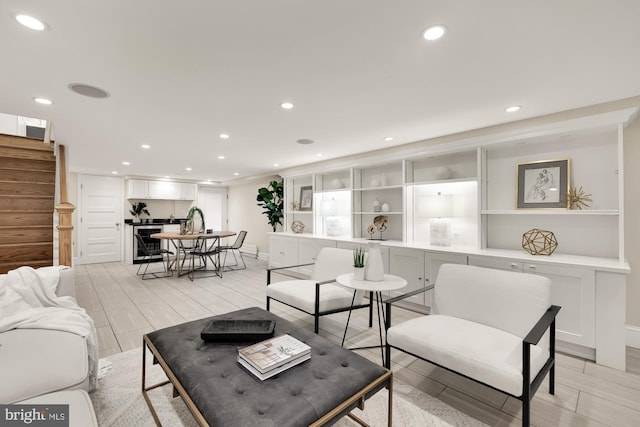 living area with baseboards, wood tiled floor, beverage cooler, stairway, and recessed lighting