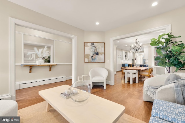 living room featuring a baseboard heating unit, baseboards, a chandelier, recessed lighting, and wood finished floors