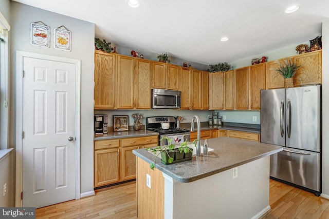7721 Sullivan Cir, Alexandria, VA 22315 - kitchen with recessed lighting, light wood finished floors, a center island with sink, and stainless steel appliances
