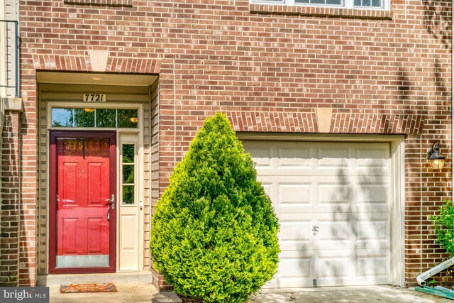 7721 Sullivan Cir, Alexandria, VA 22315 - property entrance with brick siding, driveway, and a garage
