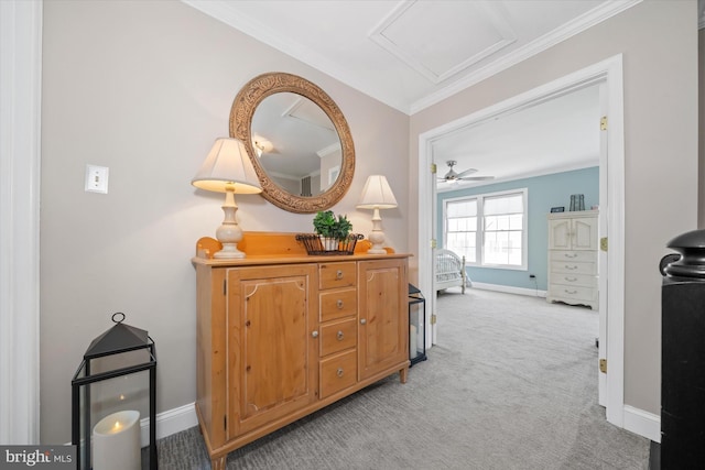 corridor with baseboards, light colored carpet, attic access, and ornamental molding