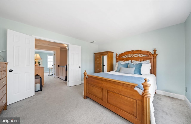 bedroom with visible vents, baseboards, and light carpet