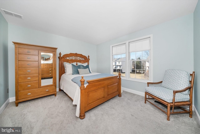 bedroom with visible vents, light colored carpet, and baseboards