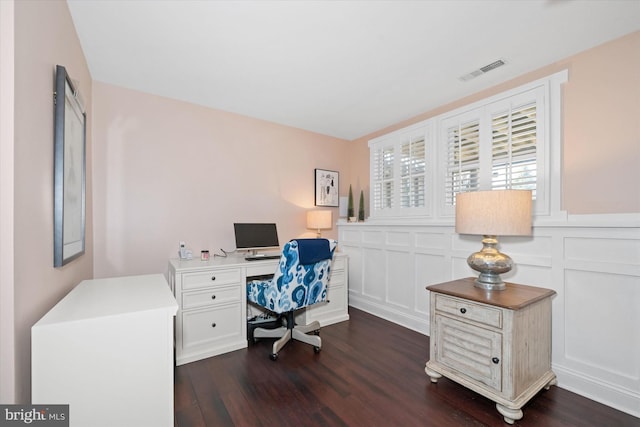 office area with dark wood-style floors, visible vents, wainscoting, and a decorative wall