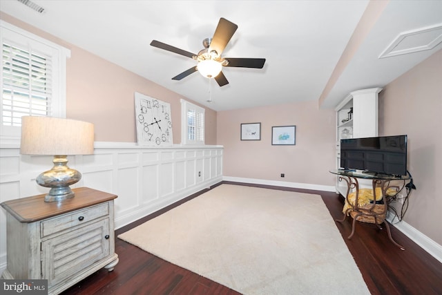 sitting room with visible vents, baseboards, dark wood-style floors, and a ceiling fan