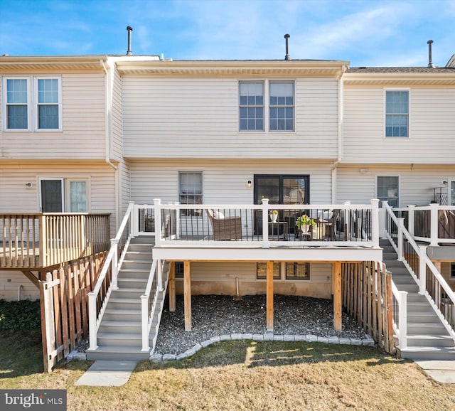 back of property featuring stairs, a deck, and a yard