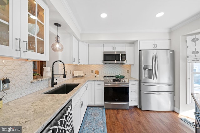 kitchen featuring a sink, white cabinetry, appliances with stainless steel finishes, crown molding, and glass insert cabinets