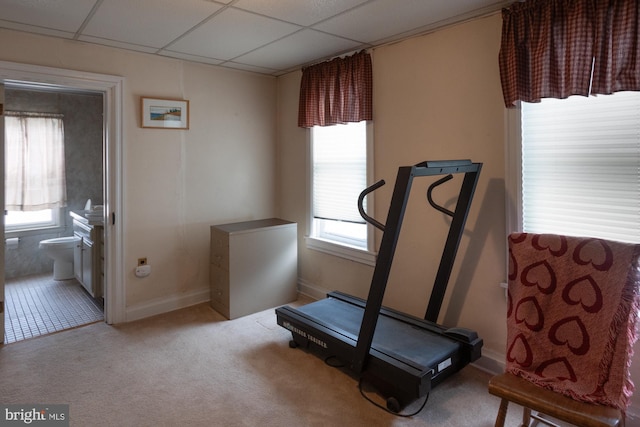 workout room with a wealth of natural light, light colored carpet, a paneled ceiling, and baseboards