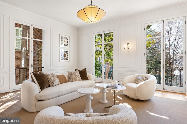 living area featuring crown molding and a decorative wall