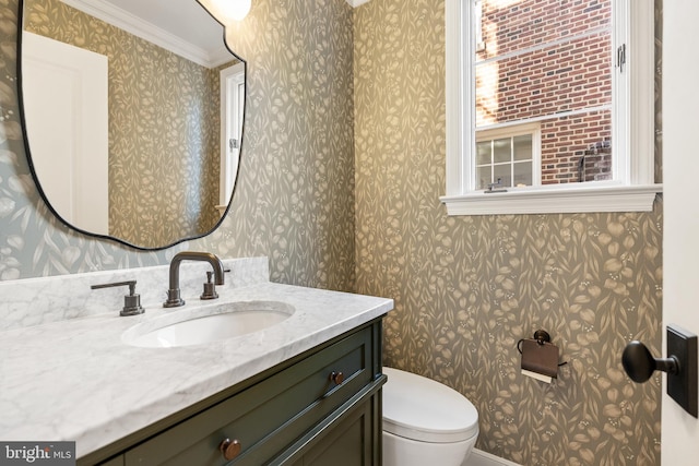 half bathroom with wallpapered walls, toilet, and vanity