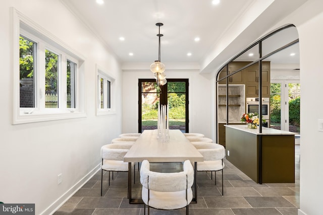 dining space with recessed lighting, a healthy amount of sunlight, crown molding, and baseboards