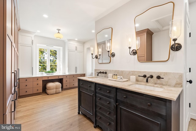 full bathroom with a sink, recessed lighting, wood finished floors, and double vanity