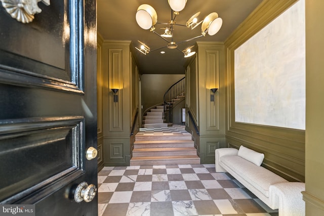 stairs featuring a notable chandelier and a decorative wall