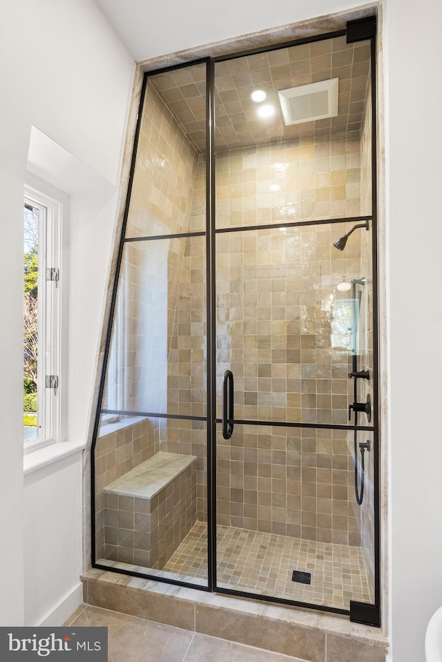 bathroom with a shower stall and baseboards