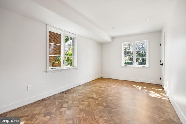 empty room with visible vents, baseboards, and a healthy amount of sunlight