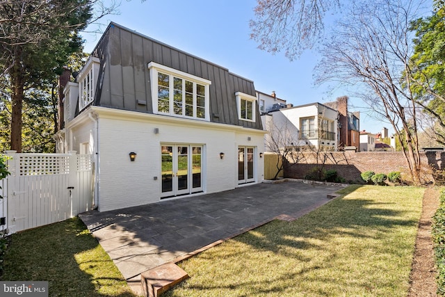 rear view of property featuring a yard, a patio, board and batten siding, and fence