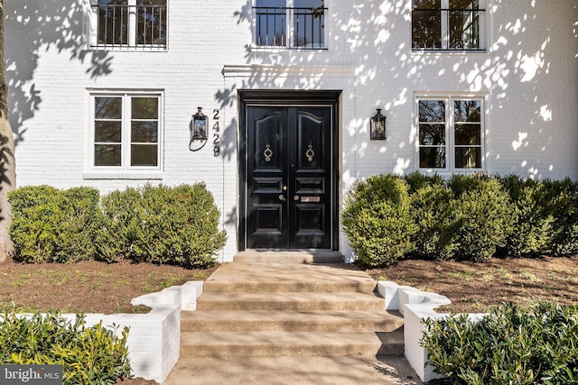 view of exterior entry with brick siding and french doors