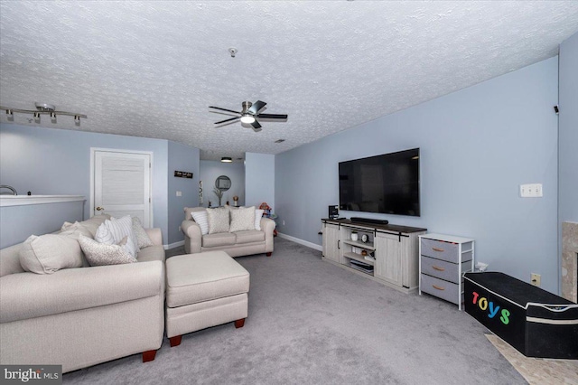 living area featuring a textured ceiling, a ceiling fan, and light carpet