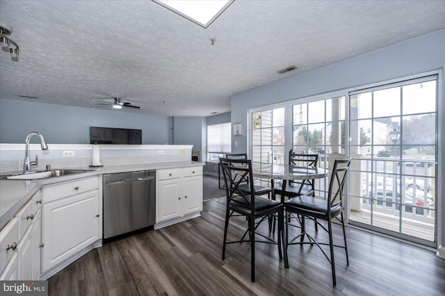 kitchen featuring a sink, light countertops, stainless steel dishwasher, white cabinetry, and dark wood-style flooring