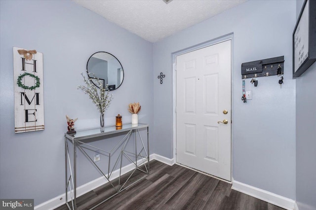 entrance foyer featuring dark wood finished floors, a textured ceiling, and baseboards