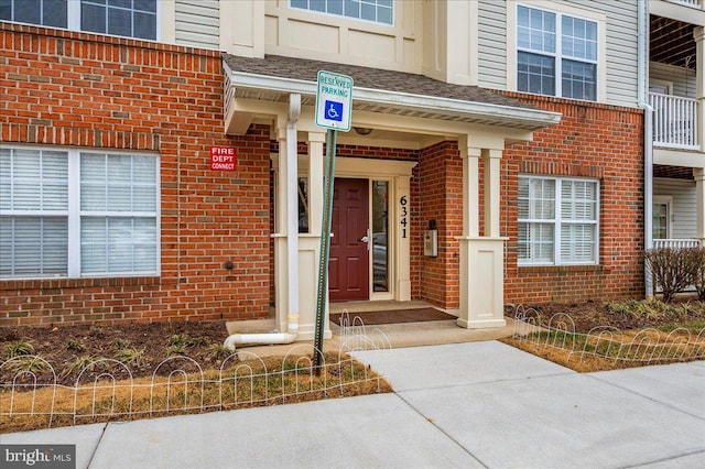 view of exterior entry featuring brick siding