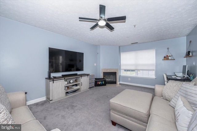 carpeted living room with a fireplace with flush hearth, a ceiling fan, baseboards, and a textured ceiling