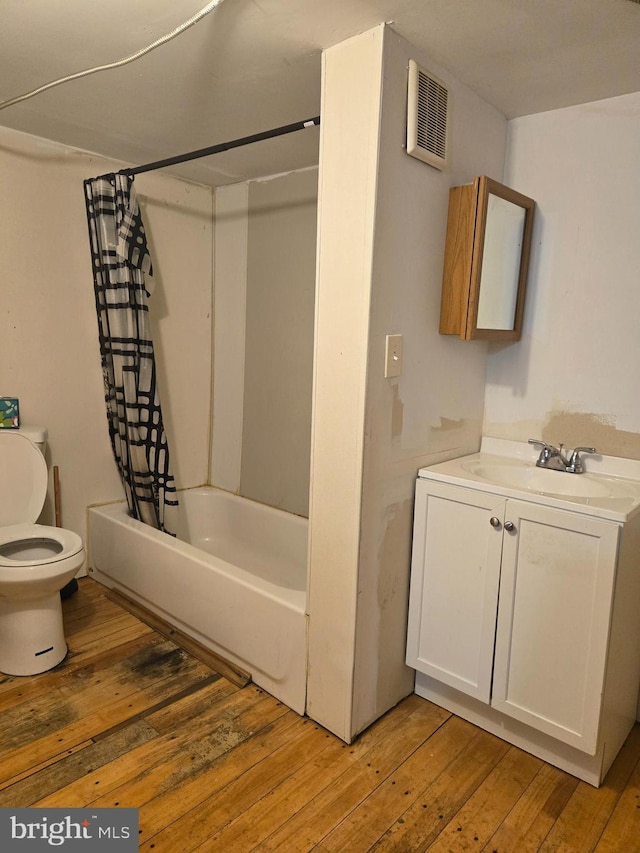 bathroom with visible vents, toilet, shower / tub combo with curtain, and hardwood / wood-style flooring