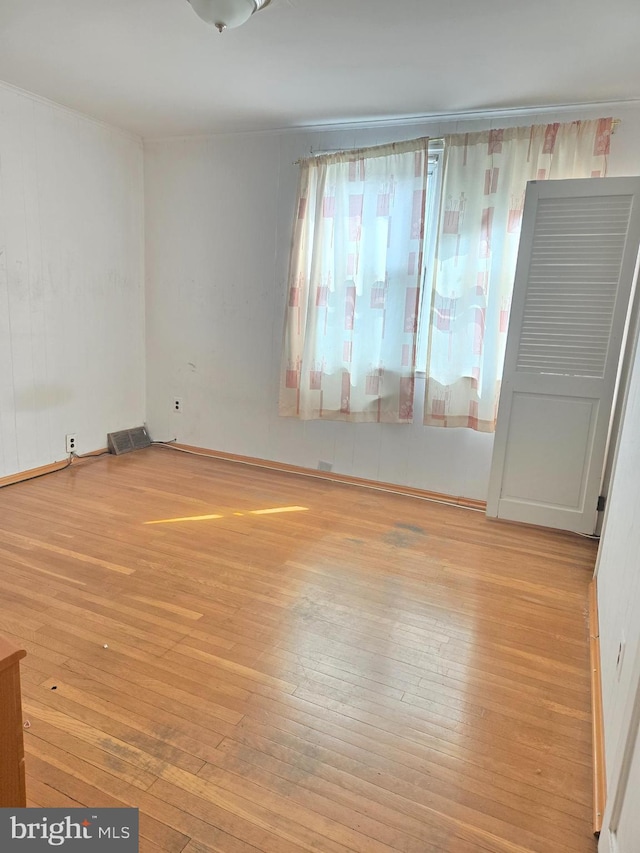 spare room featuring visible vents and hardwood / wood-style floors