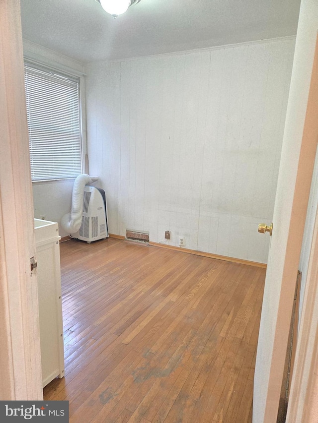 unfurnished room featuring visible vents and hardwood / wood-style flooring