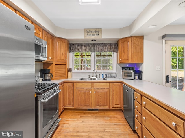 2446 Saint Lukes Rd, Salisbury, MD 21804 - kitchen featuring appliances with stainless steel finishes, a sink, light wood-style flooring, light countertops, and recessed lighting