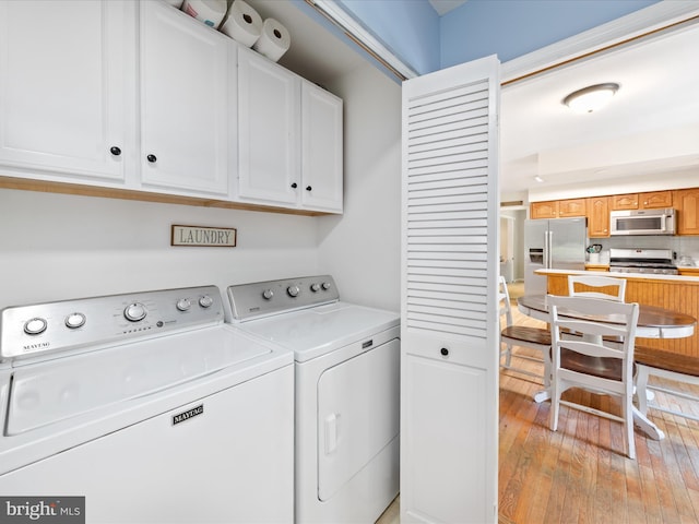 2446 Saint Lukes Rd, Salisbury, MD 21804 - washroom featuring cabinet space, washer and dryer, and light wood-type flooring