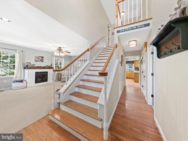 2446 Saint Lukes Rd, Salisbury, MD 21804 - stairway with wood finished floors, a glass covered fireplace, baseboards, and a ceiling fan