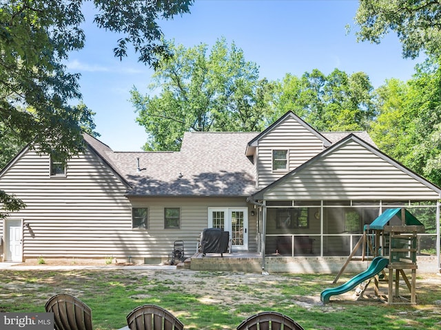 2446 Saint Lukes Rd, Salisbury, MD 21804 - back of property featuring an outdoor fire pit, a sunroom, roof with shingles, a playground, and a yard