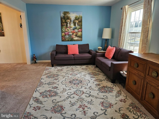 living area with baseboards and light carpet