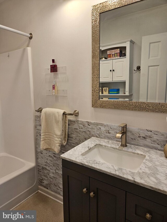 full bath featuring vanity and baseboards