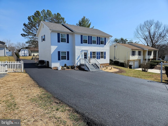 view of front of house with aphalt driveway and fence