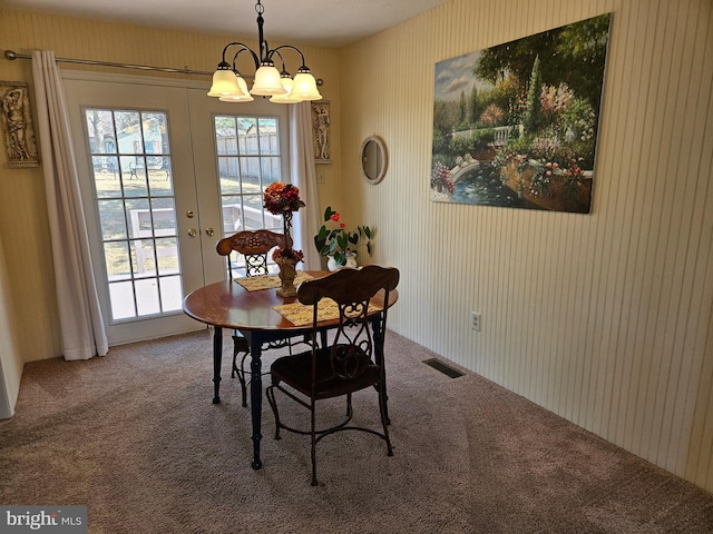 dining room with a notable chandelier, carpet flooring, a healthy amount of sunlight, and visible vents