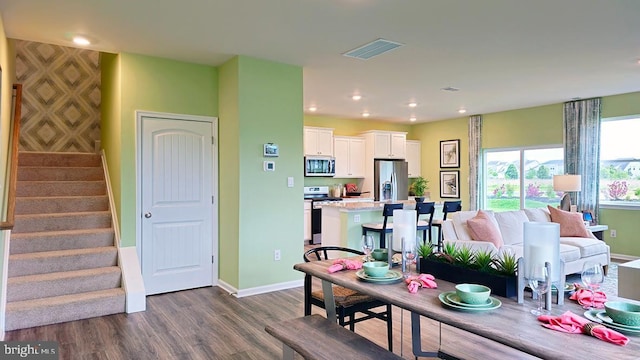 living room with visible vents, baseboards, dark wood finished floors, stairway, and recessed lighting