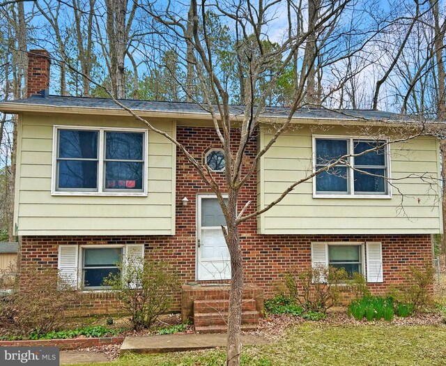 bi-level home with brick siding and a chimney