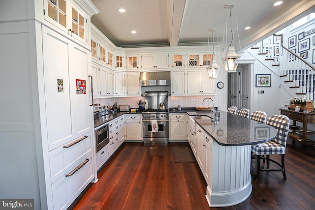 1 103rd St, Stone Harbor, NJ 08247 - kitchen featuring ventilation hood, a peninsula, a sink, appliances with stainless steel finishes, and a kitchen breakfast bar
