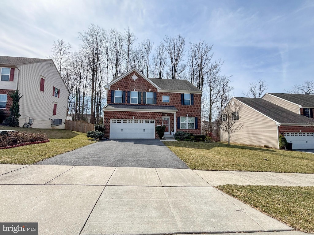 view of front of home featuring driveway, a front lawn, fence, an attached garage, and brick siding