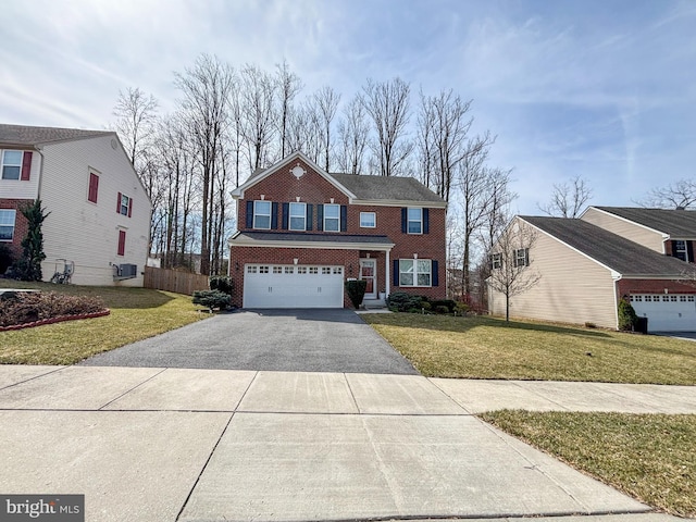 view of front of home featuring driveway, a front lawn, fence, an attached garage, and brick siding