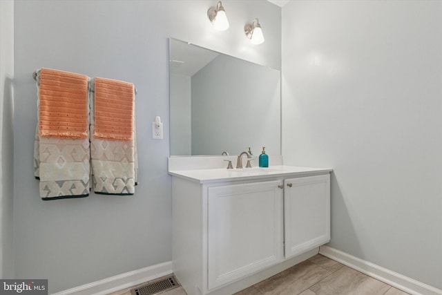 bathroom featuring vanity, baseboards, and visible vents