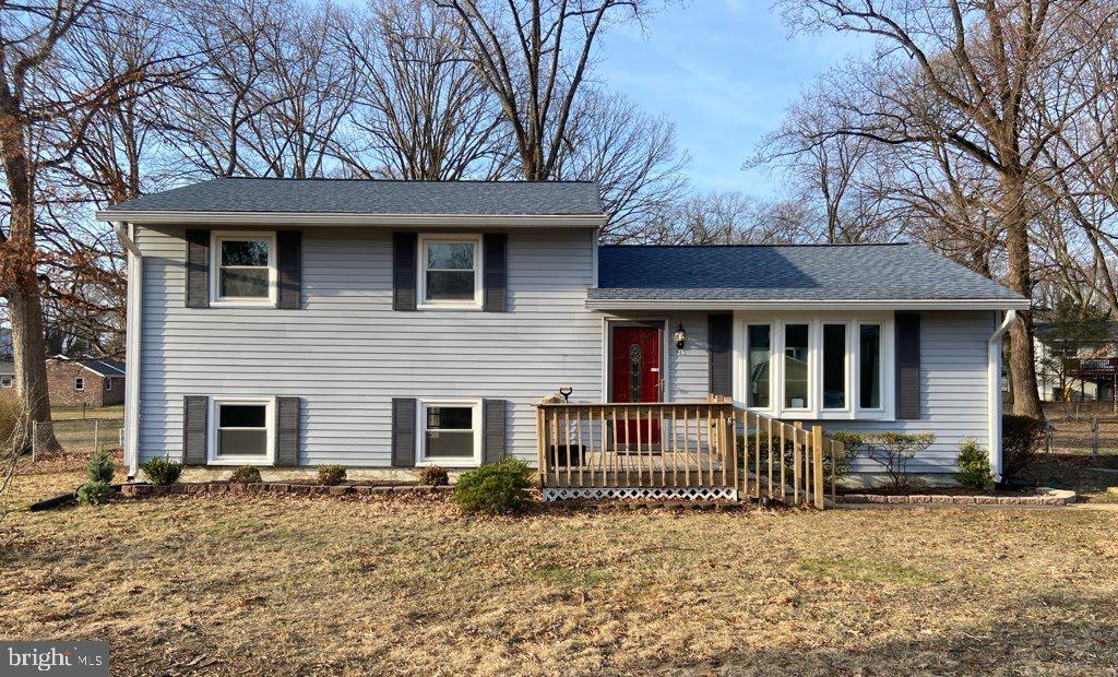 split level home with a front lawn and a shingled roof