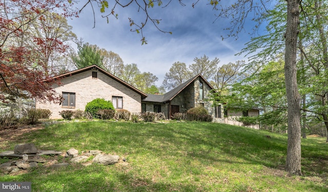 exterior space with a yard, brick siding, and stone siding